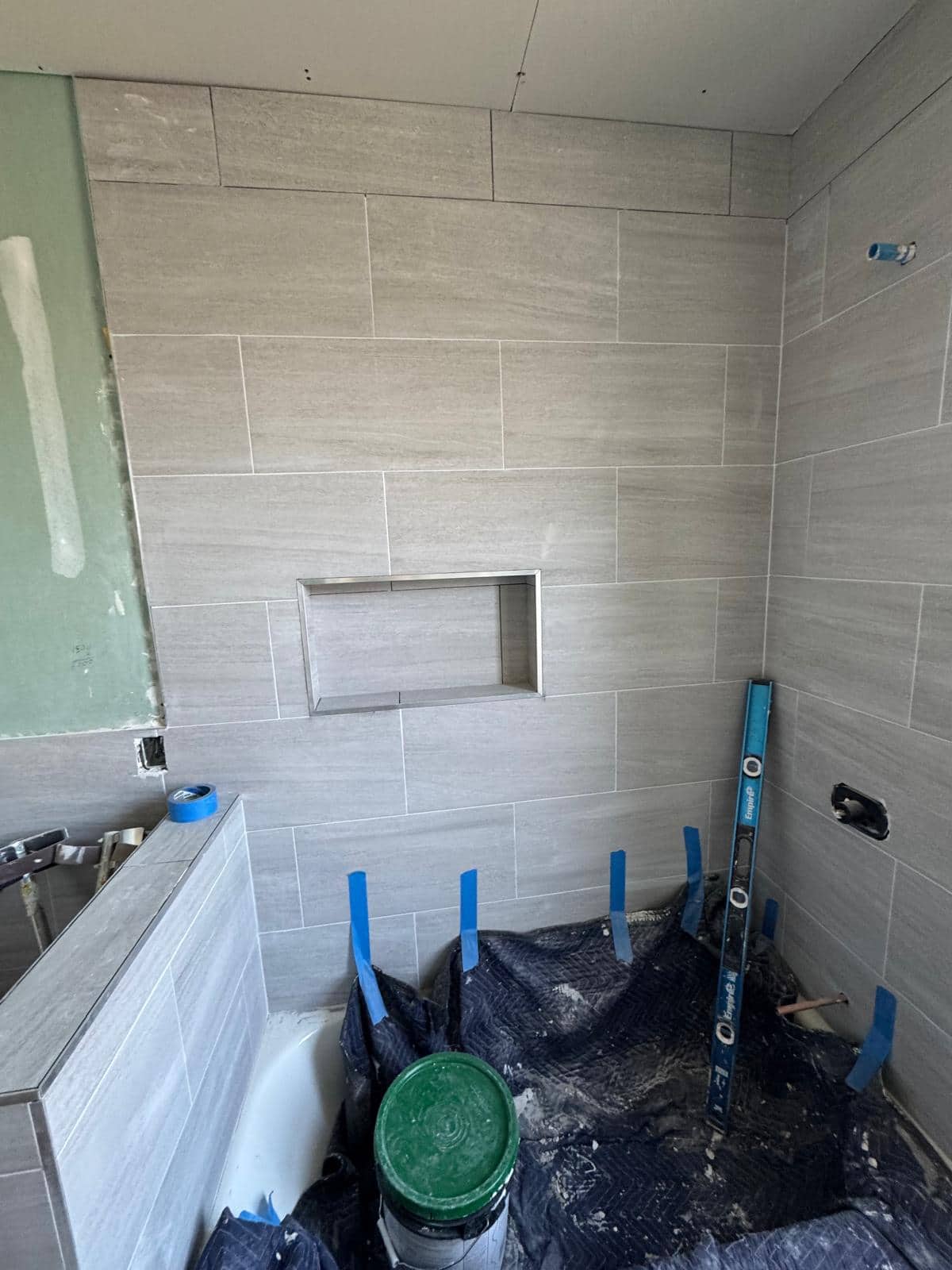 Marble-look shower tile and glass detail for a Jackson Heights bathroom remodeling planning guide.