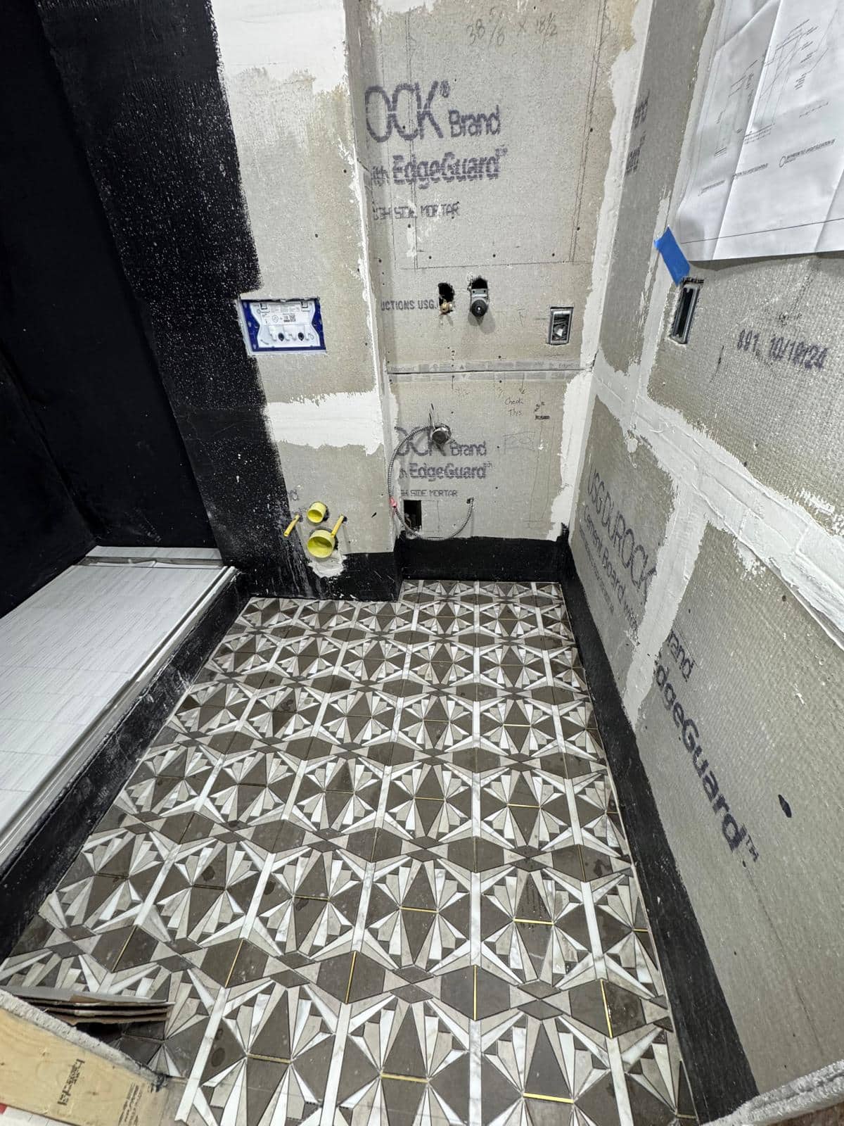 This second view of a patterned floor shows more of its relationship to the unfinished shower area.
