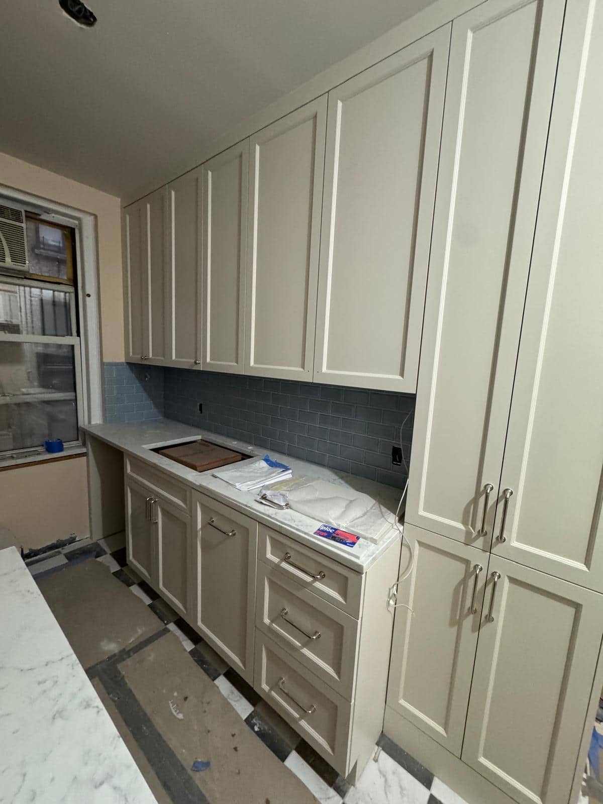 Cream cabinets and a blue backsplash make this kitchen feel warm without losing contrast.