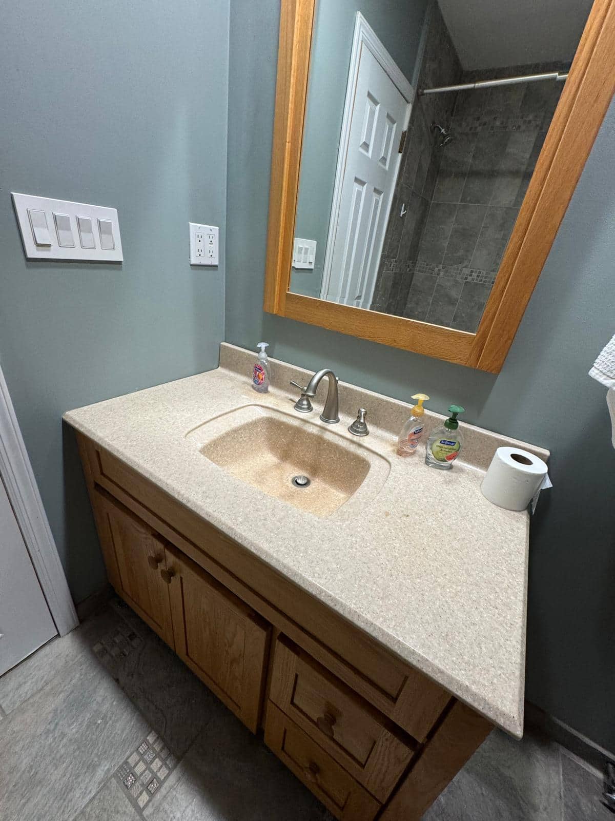 A dark vanity, pale counter, and mirror create a clear focal point in this bathroom.