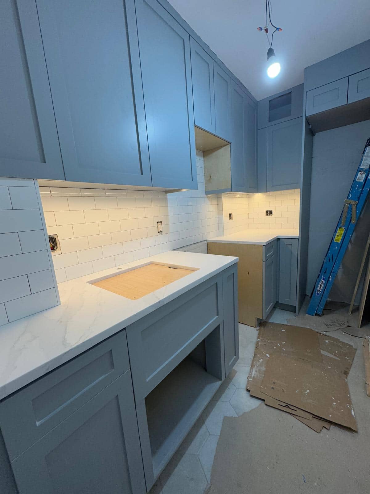 Blue cabinetry and tile are visible while this kitchen is still being worked on.