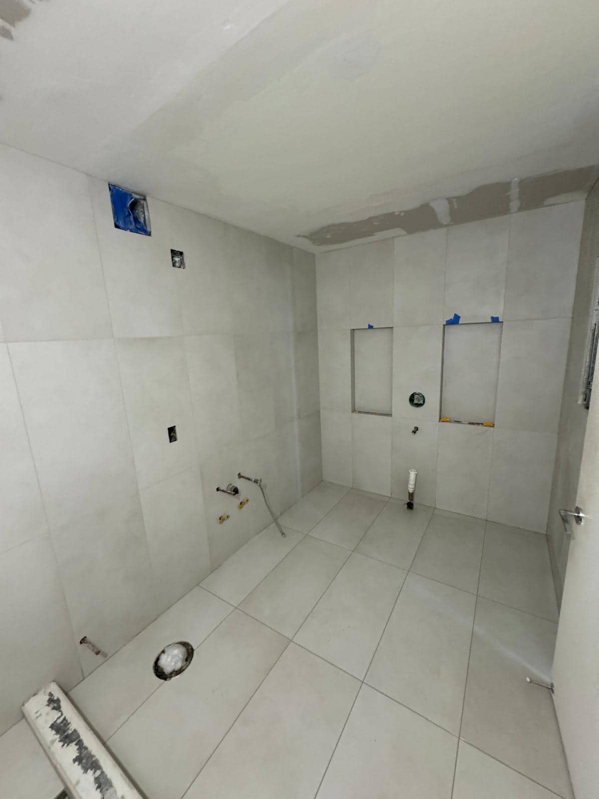 White tile shower work for a Ridgewood, Queens bathroom remodeling planning guide.
